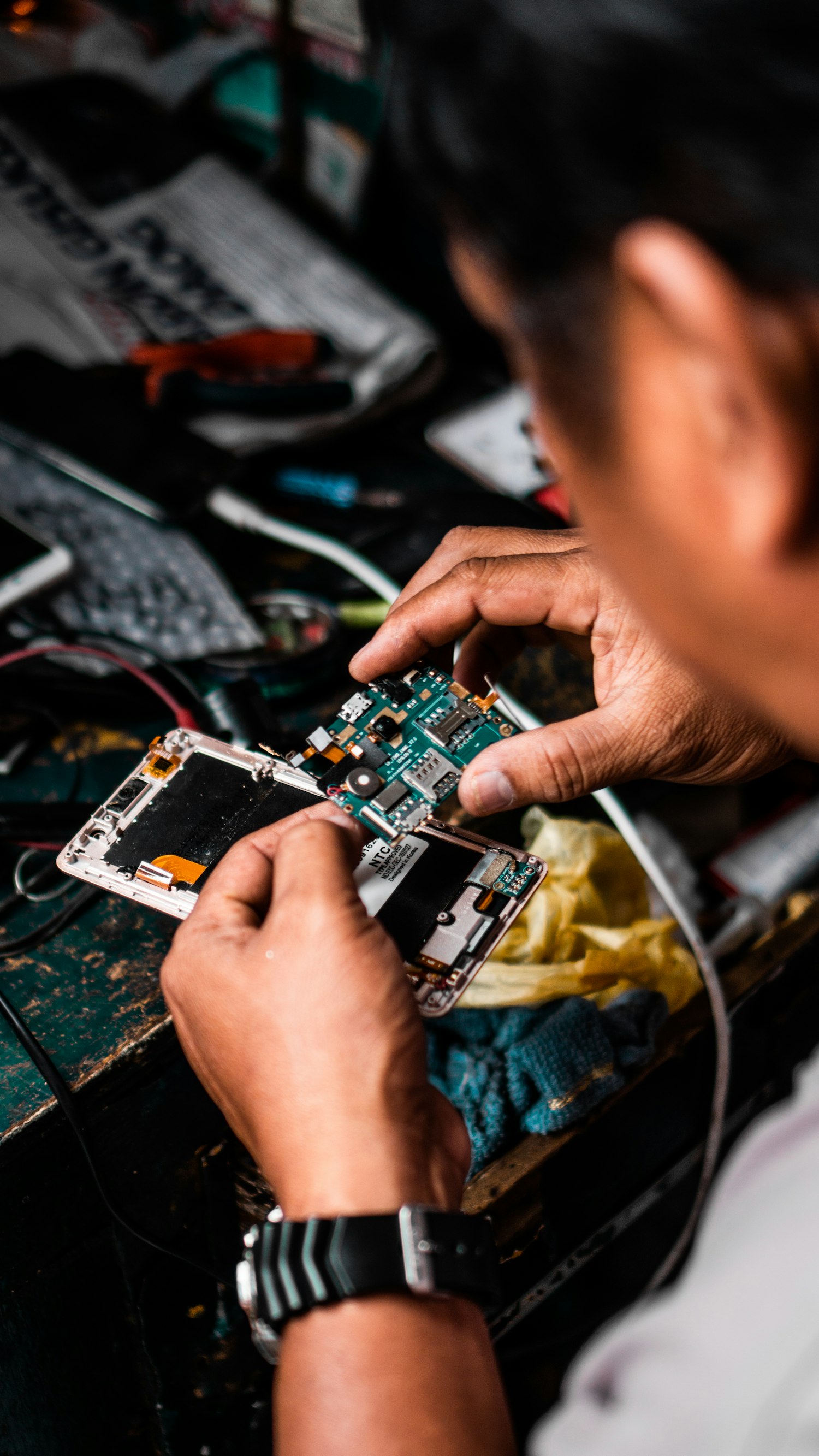 Técnico consertando a placa de um celular